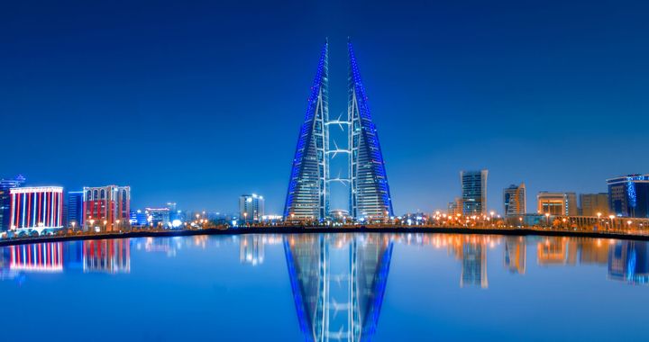 The Bahrain World Trade Center and Manama skyline reflected in the bay at dusk