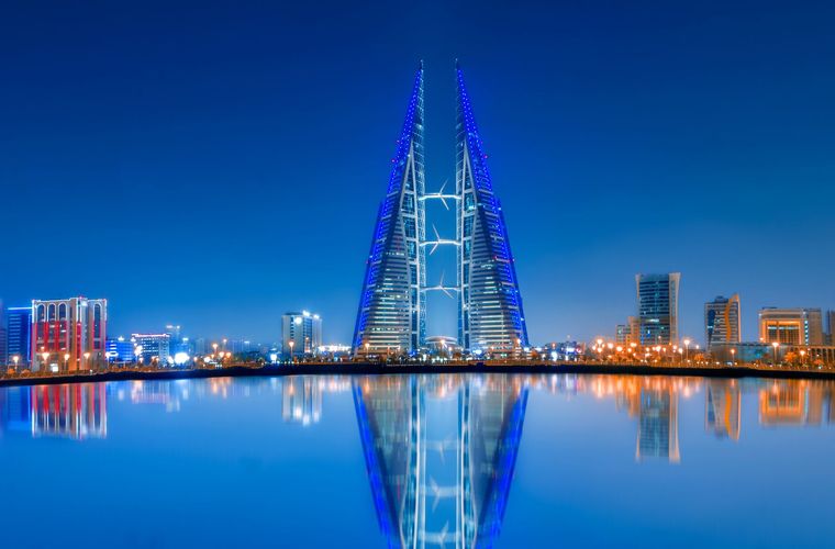 Manama skyline at dusk with the Bahrain World Trade Center reflected in the water