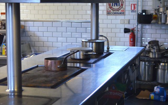 A spotless stainless steel counter in a professional restaurant kitchen