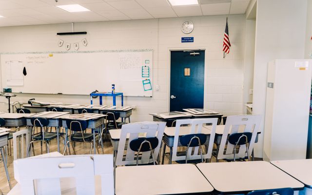 A clean, empty classroom with desks arranged ready for pupils